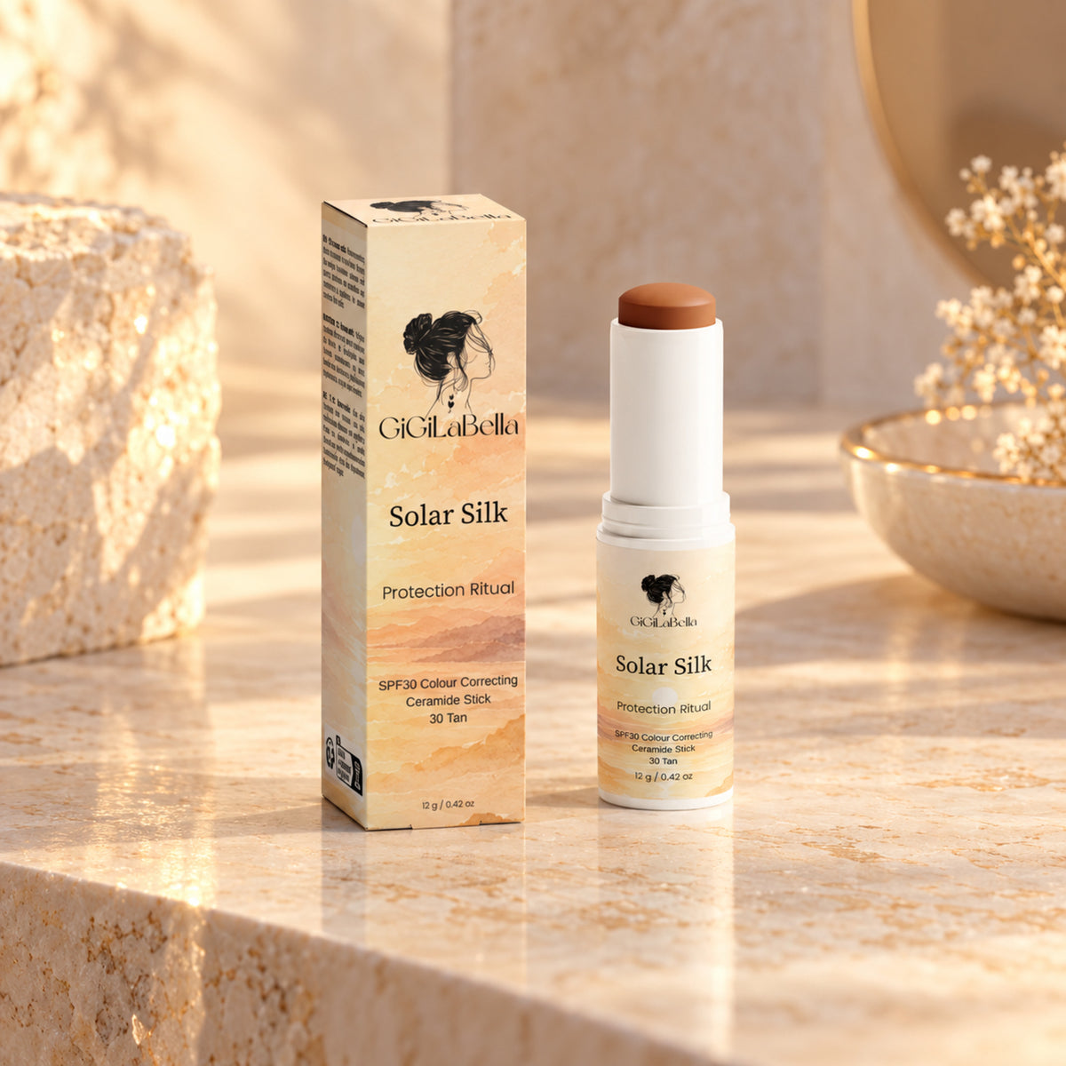 GiGiLaBella Solar Silk SPF30 colour-correcting ceramide stick in shade 30 Tan with carton on a warm limestone vanity
