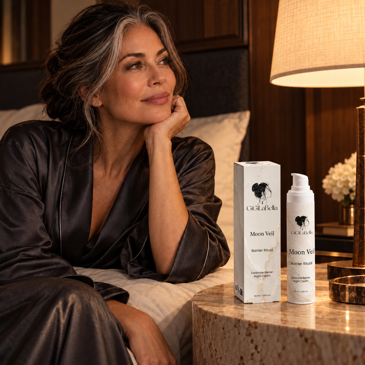 Mature woman beside Moon Veil night cream in an evening bedroom ritual