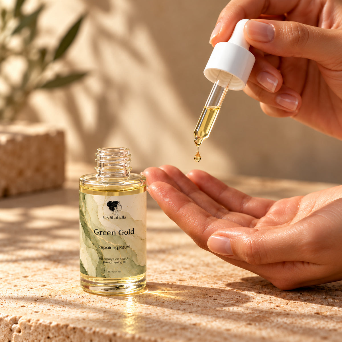 Green Gold oil dropper dispensing a golden drop into the palm beside the GiGiLaBella bottle